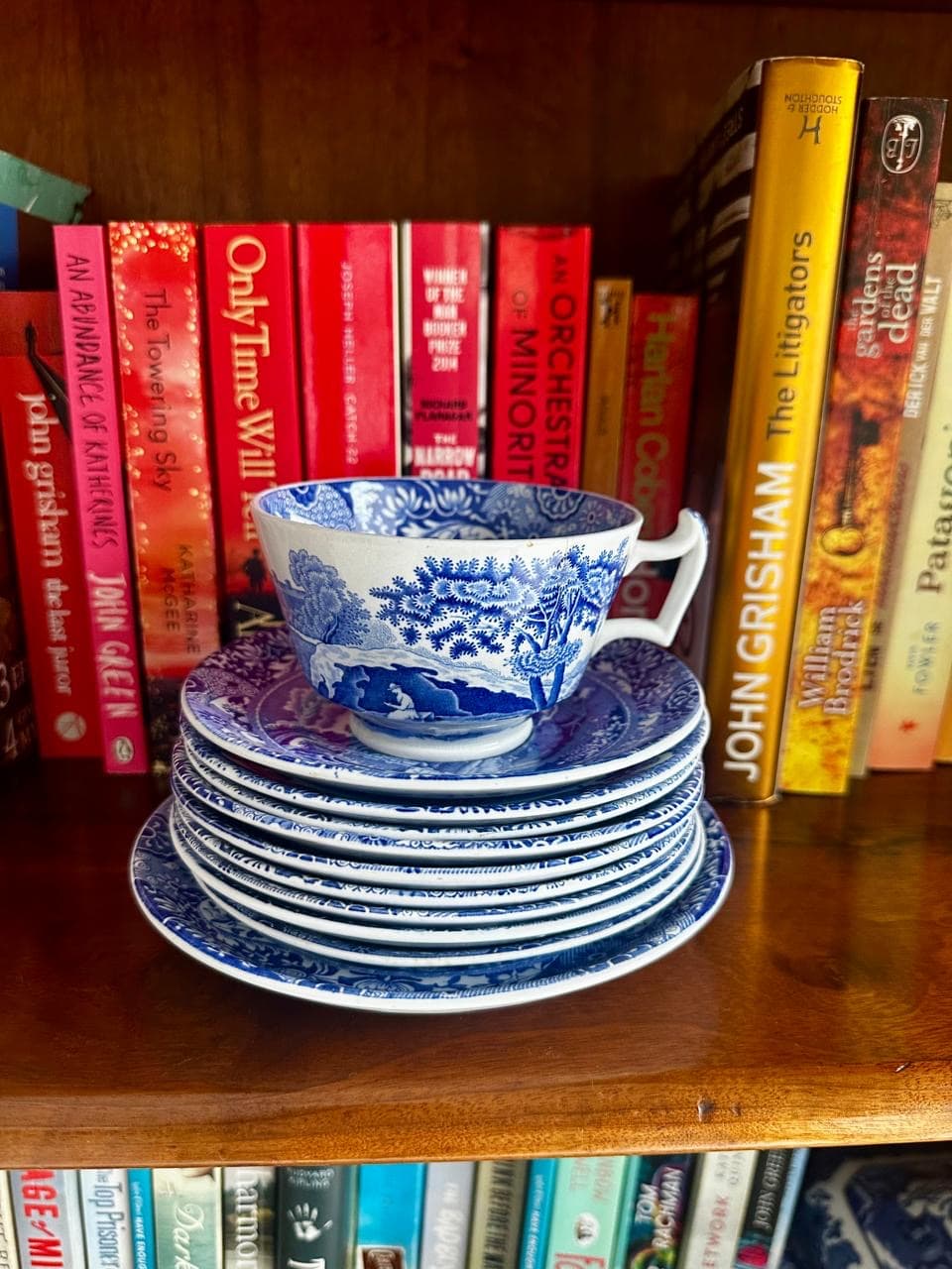 Stack of plates and cups infront of books